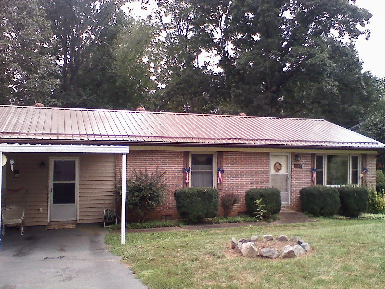 Bronze metal roof and carport on a brick ranch home — Roof Repair work by our crew in Mchenry